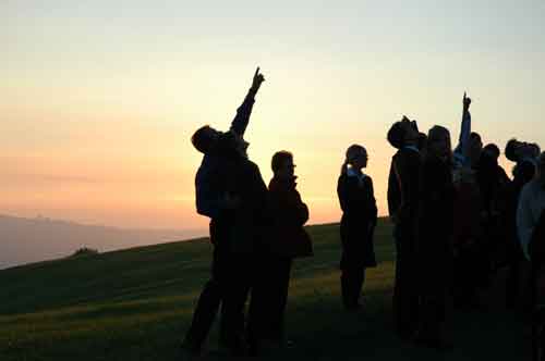 Foto: Menschengruppe die zum Himmel deutet